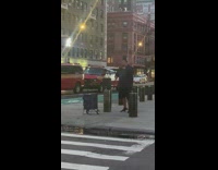 Man singing karaoke through speakers on corner of street