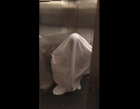 Girl in white sheet runs out of elevator and hits head on wall