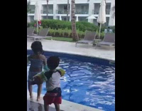 little boy pushes girl into pool 