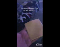 Father puts a slice of cheese on his babys face 
