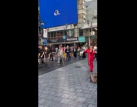 Man red suit dances on the sidewalk