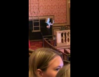 Woman in black dress vlogs inside the theatre