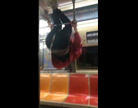 man red sweater upside down on subway rail