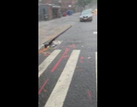 Submitter shows heavy rain while crossing street 