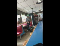 IITW - Woman taking pictures in diner with menu in hand 