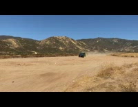 Black jeep car drives jumps dirt desert 