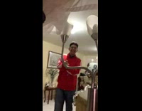 Guy red adidas jacket makes hand gang signs to music behind lamp