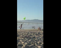 Woman leg up hold green balloons beach