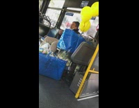 Guy on bus flosses teeth yellow balloons