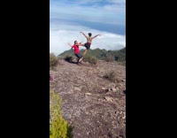 Hiker couple balances for photo near ledge