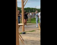 Collab IITW - Woman in blue top black handbag poses while people walks past her