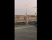 Man climb stand lamppost parking lot photographer