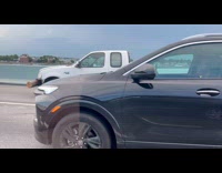 Truck drives with wood log on bumper