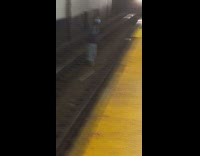 Man blocking subway train by standing on train track