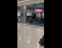 Two women dance tiktok airport lobby chairs