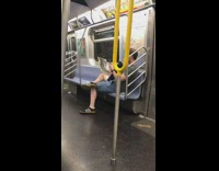 Man holds a picture of a penis and takes a picture of it on his phone on the subway