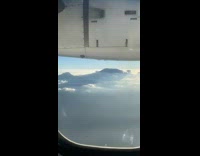 Airplane plane window tall mountains white cloud