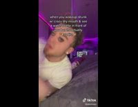 Guy purple light room wakes up drinks water bottle