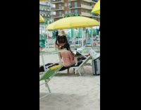 Woman black bikini beach hat poses umbrella