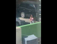 Woman in pink crop top floral pants tiktok dance outside the house