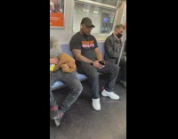 Guy on subway with Suck on Dznuts shirt