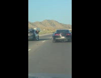 Guy leans out window photographs black car