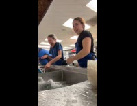 Woman splash water dips coworker on sink