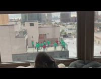 People on roof play tug of war from squid game