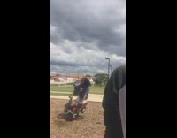 Woman on pogo stick car at playground falls onto floor