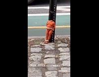 Headless doll tied to metal pole outside 