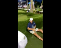 Guy carrying drinks slips mini golf 