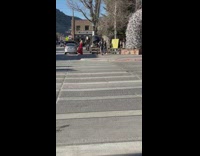 Lady Wearing Red Cape Poses on Sidewalk for Photos 