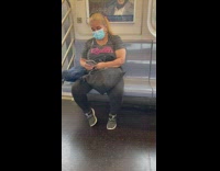 Lady riding train has bug on mask