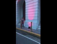 Woman elbow on golden pole pink light