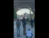 Middle aged men posing with Eiffel Tower