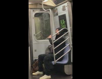 Guy practicing the flute while sitting on subway train 
