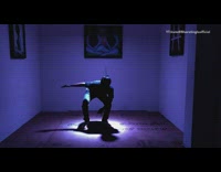 Guy dances dim purple lighting room 