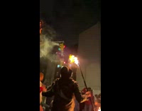 Guy holds stick with fire both sides 