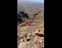 Guy wearing red wingsuit jumps off mountain 