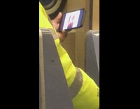 Man yellow jacket watches naked woman twerk on his phone on subway train