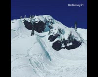 Guy jumps his snowmobile over snow hill and falls off forward