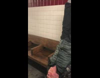 Man sits upside down on wooden bench with legs straight in the air