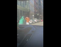 Woman in brown coat walks in the middle of the street