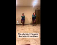 Couple plays stay behind red tape game