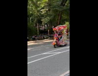 Tricycle full of decorations drive on street