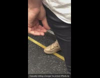 Guy rolls booger between fingers on subway train