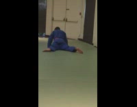 Man in blue karate uniform humps the ground during warm up exercise