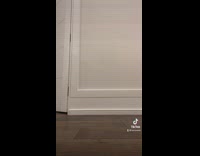 Grey cat follows woman in white pajamas