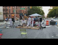 Unique band performing music and one performer is making pancakes
