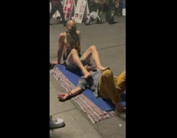 Guy gives man massage with feet at park 